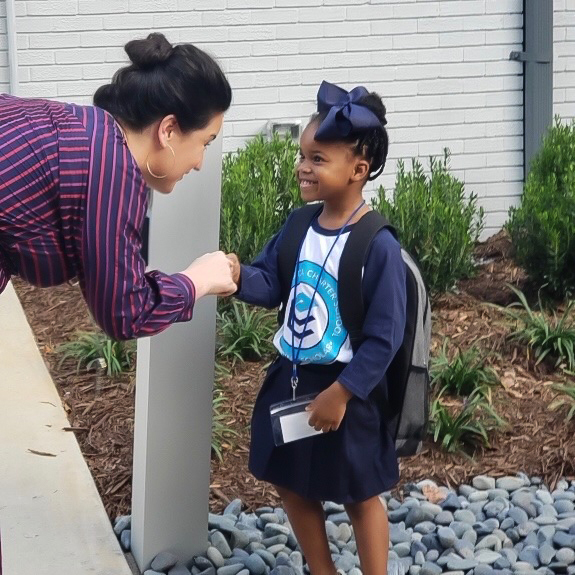 Emily Castillo Leon handshaking with a student