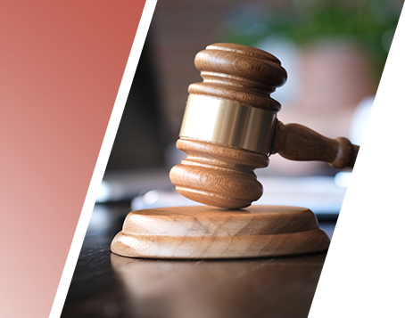A wooden gavel on top of a book on a wooden table.